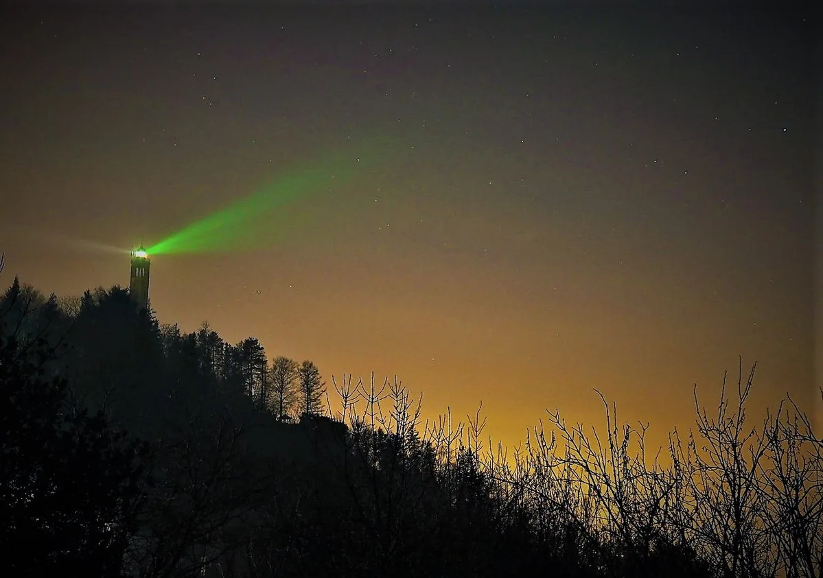 Faro Voltiano di Brunate illuminato di notte con fascio di luce verde